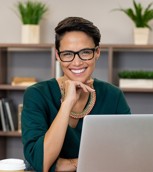 smiling woman sitting at a computer