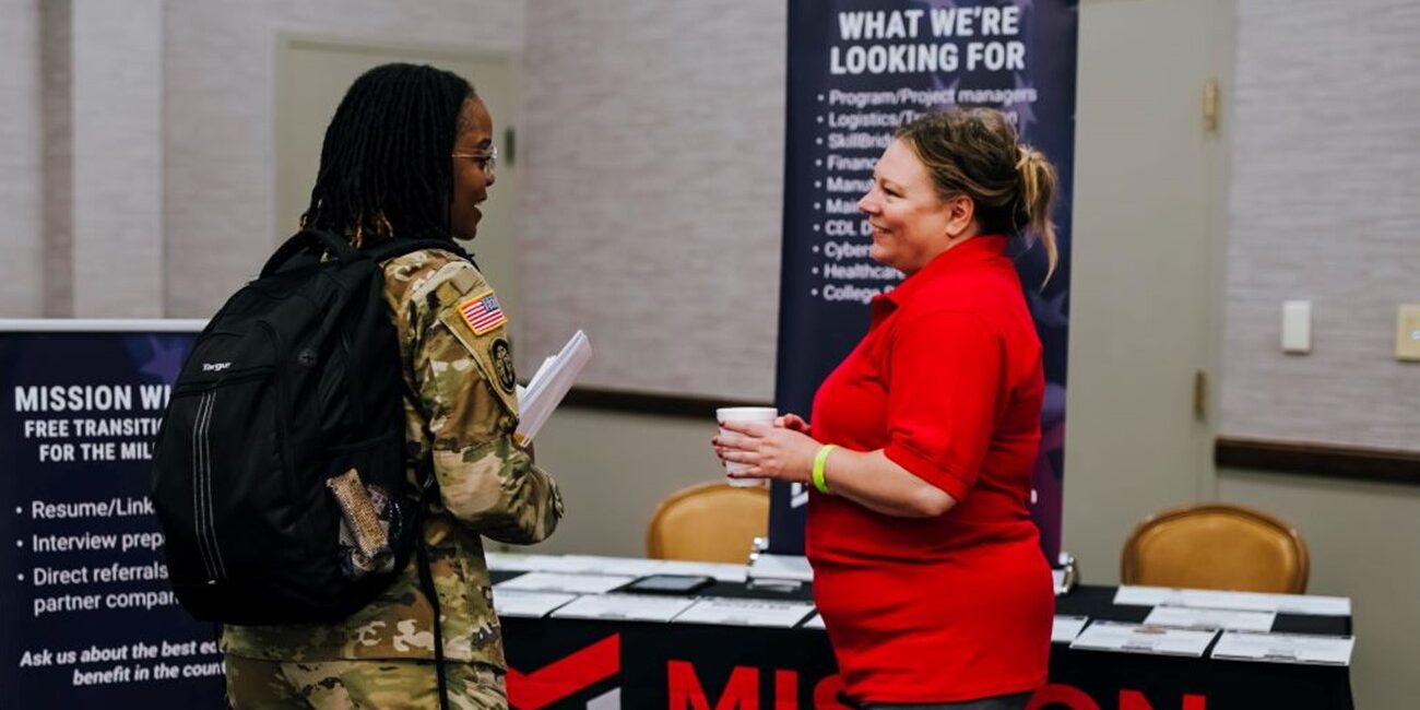 Military service member speaking with employer at a hiring event